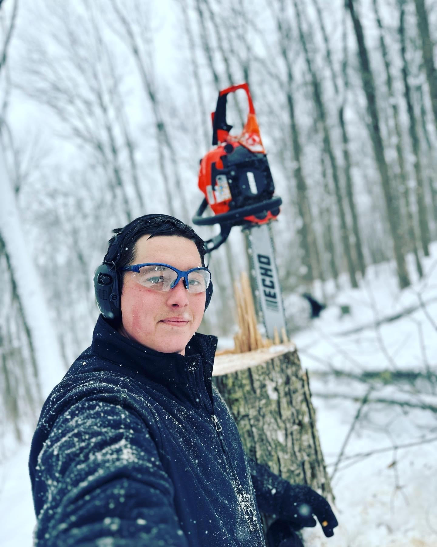A man wearing headphones standing next to a tree